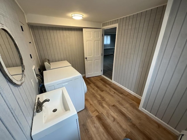 washroom featuring hardwood / wood-style flooring, independent washer and dryer, and wooden walls