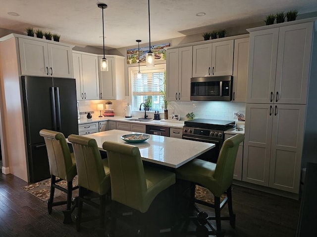 3 Panda Ct Unit 3, Milford, MA 01757 - kitchen featuring stainless steel appliances, light countertops, dark wood-type flooring, and a breakfast bar