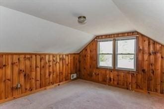 bonus room with light carpet and lofted ceiling