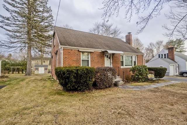 view of front of home with an outdoor structure and a front yard