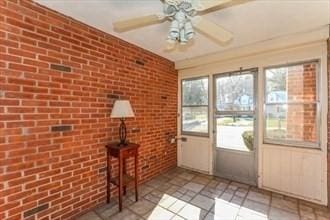 unfurnished sunroom with ceiling fan and a healthy amount of sunlight