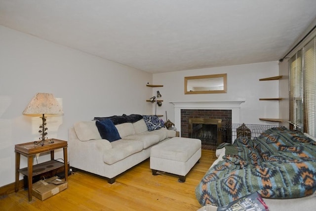 living room featuring wood-type flooring and a brick fireplace