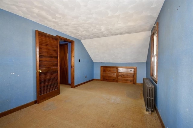 bonus room featuring baseboards, radiator, vaulted ceiling, and a textured ceiling