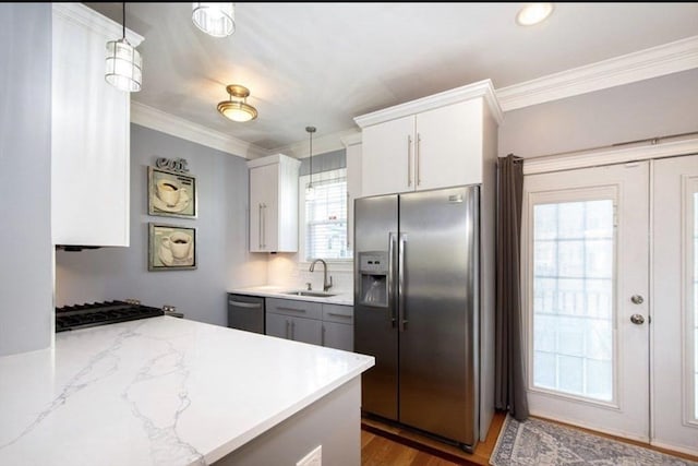 857 Adams St Unit 857, Boston, MA 02124 - kitchen with appliances with stainless steel finishes, a sink, ornamental molding, pendant lighting, and white cabinets
