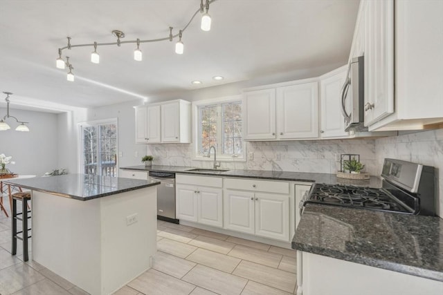 kitchen featuring appliances with stainless steel finishes, a center island, pendant lighting, and white cabinets