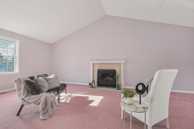 living area featuring a tiled fireplace, vaulted ceiling, and light carpet