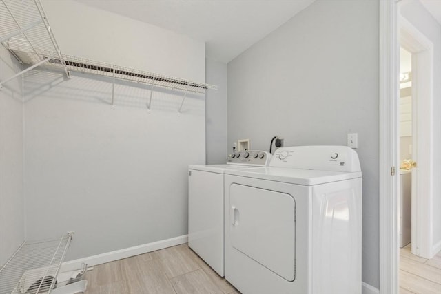 washroom with light hardwood / wood-style floors and independent washer and dryer