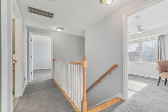 hallway featuring light colored carpet