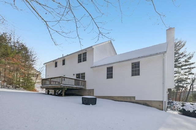 snow covered house featuring a wooden deck