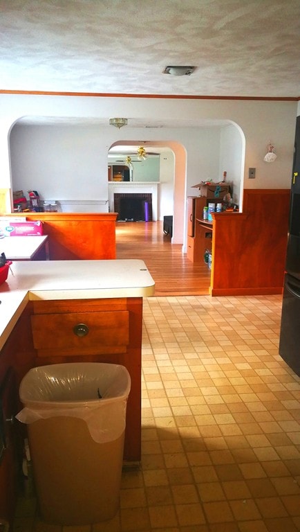 interior space featuring arched walkways, light countertops, a textured ceiling, and refrigerator