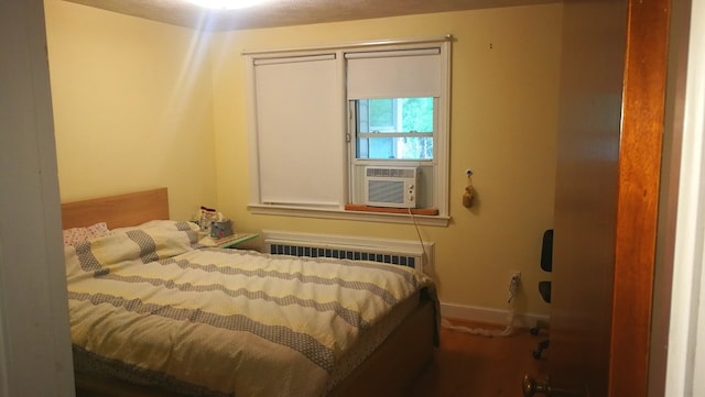 bedroom featuring cooling unit, baseboards, and radiator heating unit