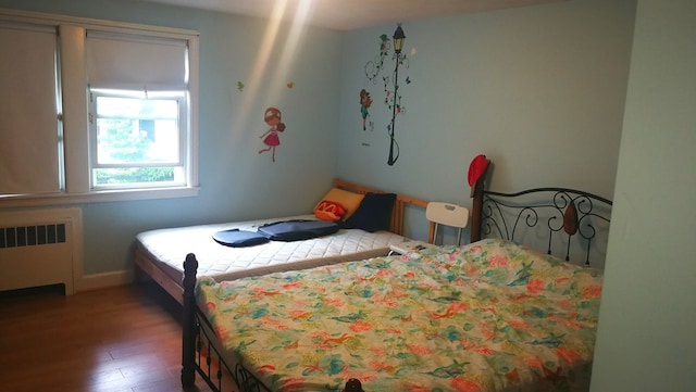 bedroom with wood finished floors and radiator