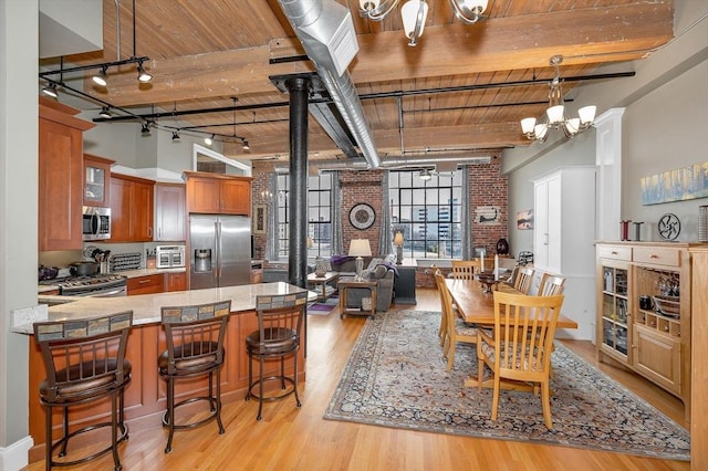 dining room with beamed ceiling, light wood-type flooring, a notable chandelier, and wood ceiling