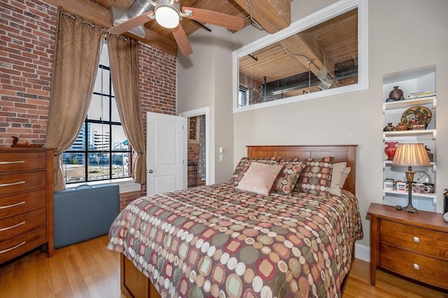 bedroom with ceiling fan, light hardwood / wood-style flooring, beamed ceiling, and wood ceiling