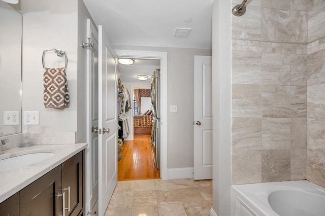 bathroom with vanity and tiled shower / bath combo