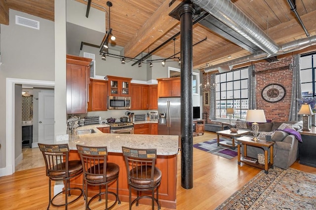 kitchen featuring kitchen peninsula, wooden ceiling, stainless steel appliances, and light hardwood / wood-style floors