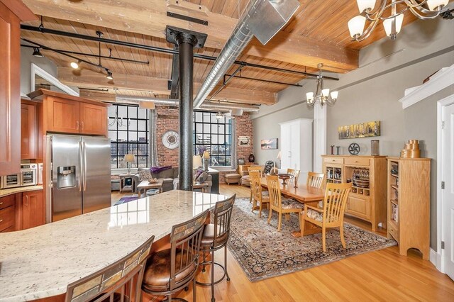 dining room with wooden ceiling, light hardwood / wood-style flooring, a notable chandelier, beam ceiling, and brick wall