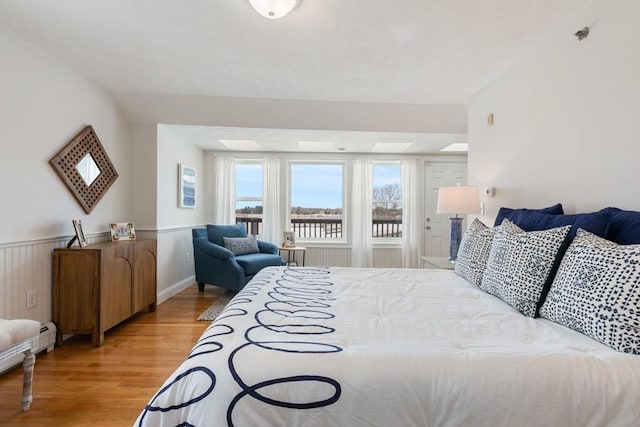 bedroom featuring light wood-type flooring and wainscoting