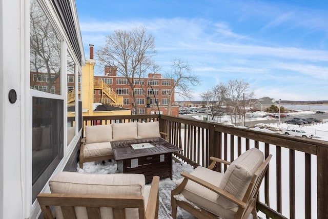 snow covered back of property featuring an outdoor living space with a fire pit