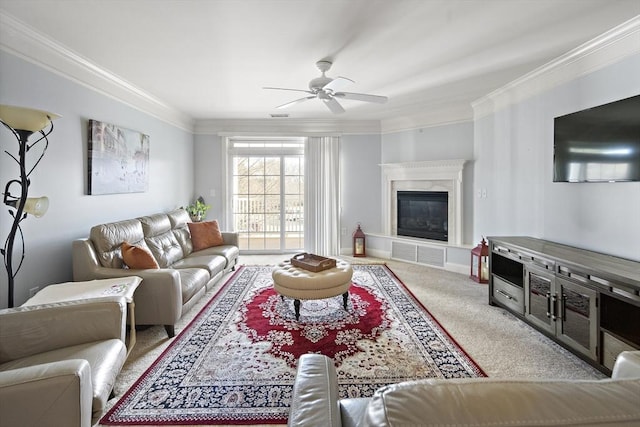 living room featuring a tile fireplace, crown molding, ceiling fan, and light colored carpet