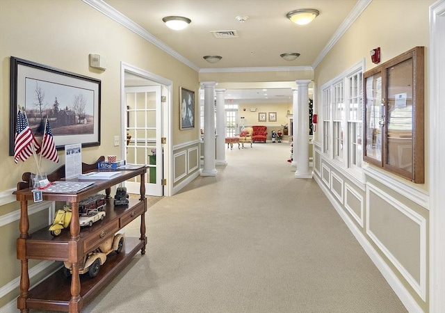 hallway with light colored carpet, ornate columns, and crown molding