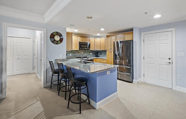 kitchen featuring kitchen peninsula, appliances with stainless steel finishes, decorative backsplash, ornamental molding, and stone countertops