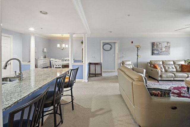 living room featuring crown molding, sink, light colored carpet, and an inviting chandelier