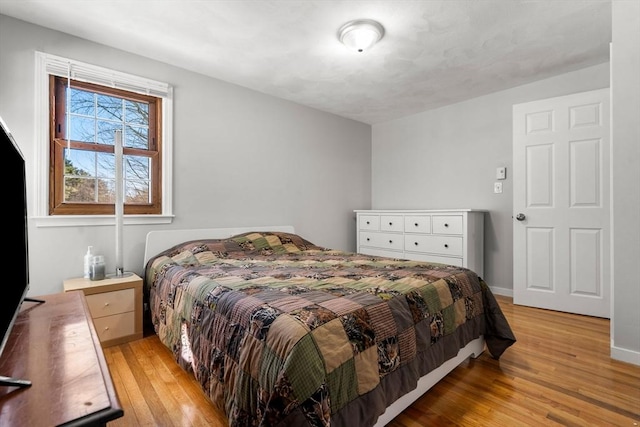 bedroom with light wood-type flooring and baseboards