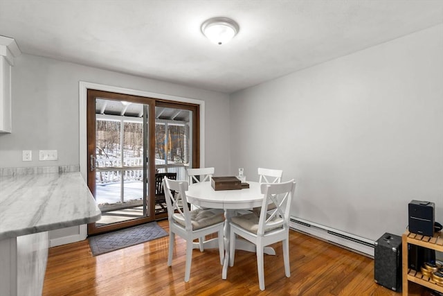 dining space featuring baseboard heating and wood finished floors