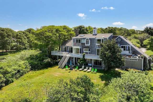 rear view of house featuring a lawn and a wooden deck