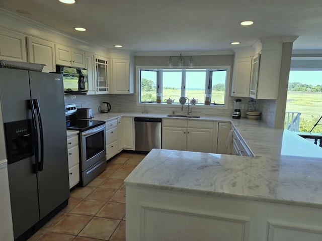 kitchen with backsplash, light stone counters, kitchen peninsula, sink, and appliances with stainless steel finishes