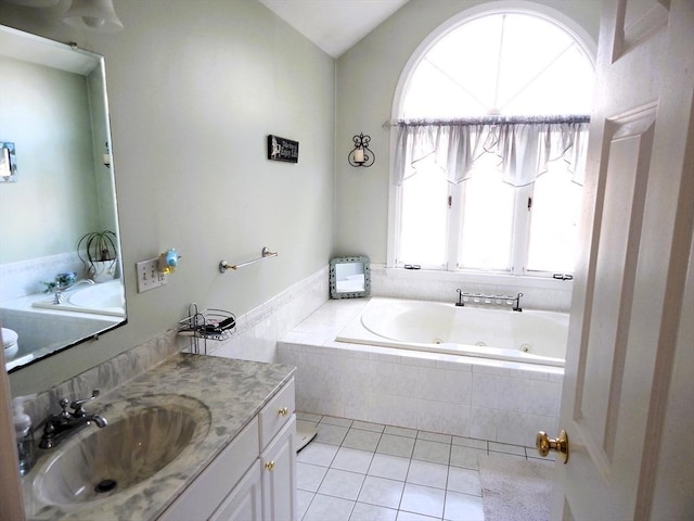 bathroom with tile patterned flooring, vanity, and a relaxing tiled tub