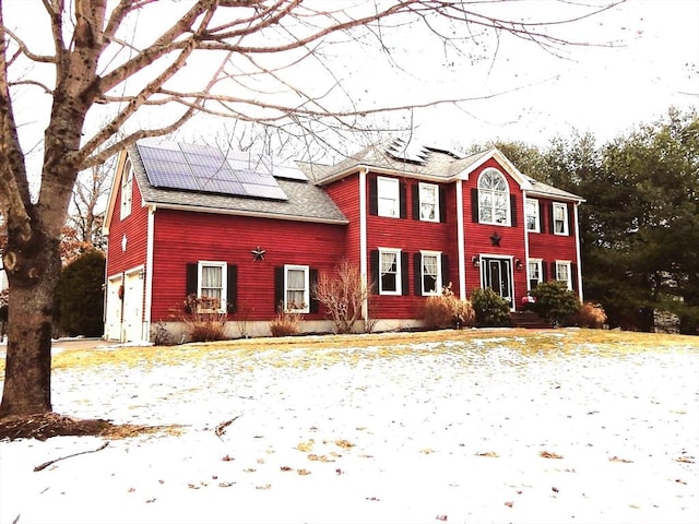 view of front facade with a garage and solar panels