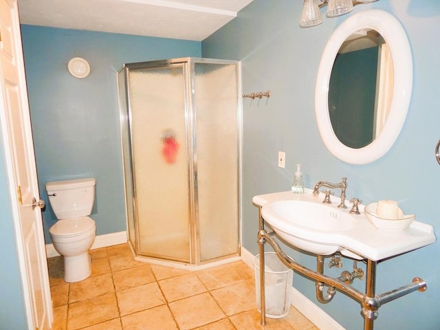 bathroom featuring tile patterned floors, toilet, and a shower with door