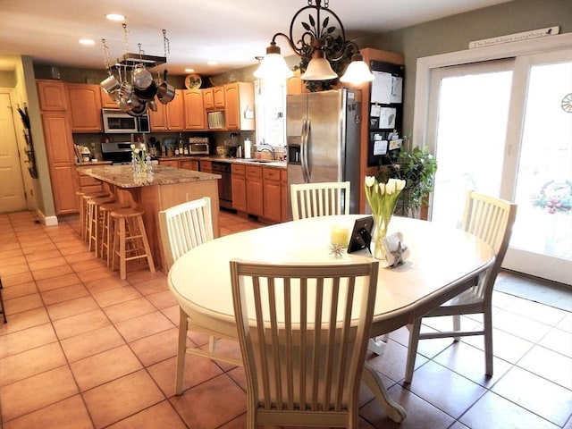 dining area featuring light tile patterned flooring, a chandelier, and sink