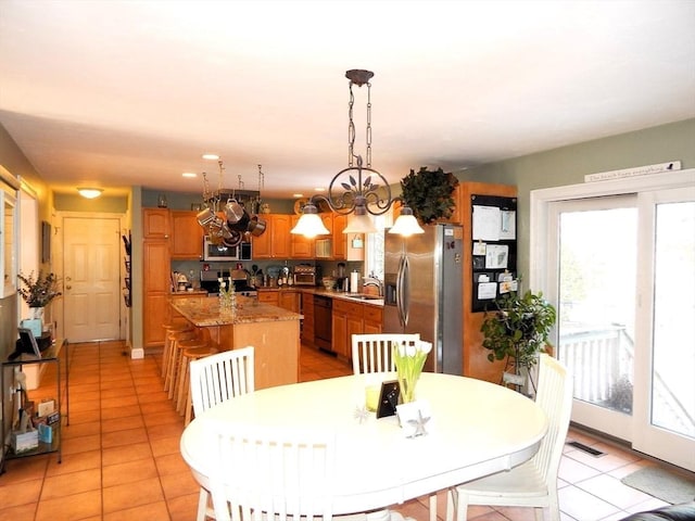 dining area featuring sink, light tile patterned floors, and a chandelier