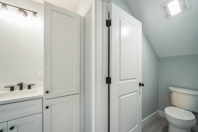 bathroom featuring toilet, lofted ceiling, vanity, and tile patterned floors