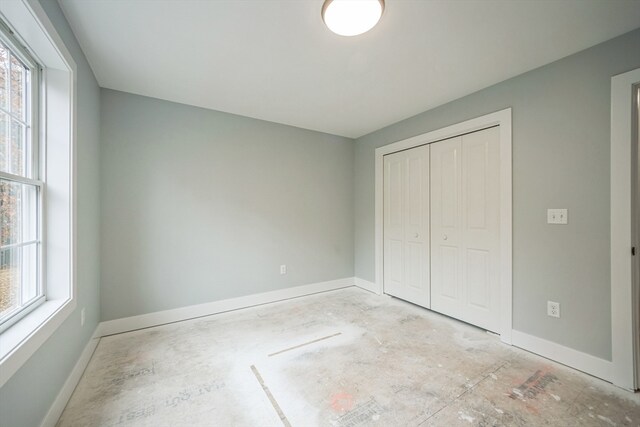 unfurnished bedroom featuring multiple windows and a closet