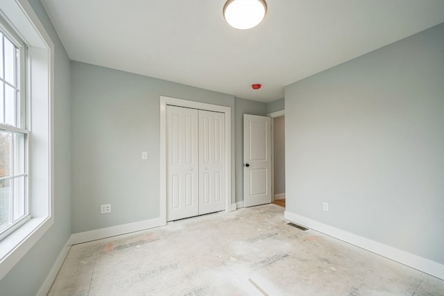 unfurnished bedroom featuring multiple windows and a closet