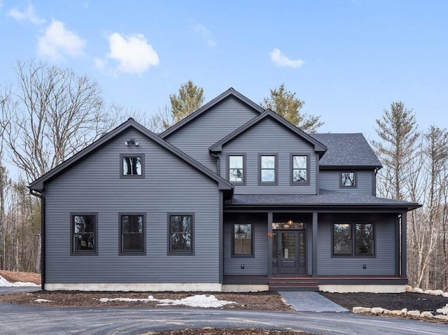 view of front of house featuring roof with shingles and covered porch