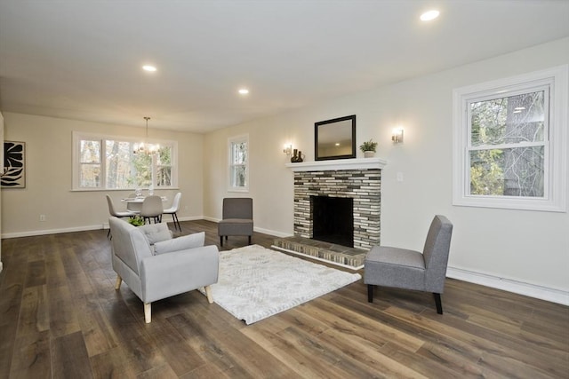 living room with dark wood-style floors, a brick fireplace, baseboards, and recessed lighting