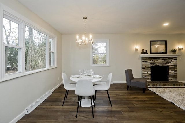 dining area featuring baseboards, dark wood finished floors, a fireplace, a notable chandelier, and recessed lighting