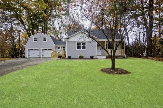 view of front of property featuring aphalt driveway, a garage, covered porch, a gambrel roof, and a front yard