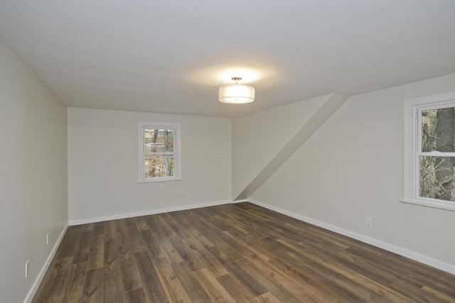 unfurnished room with dark wood finished floors and baseboards