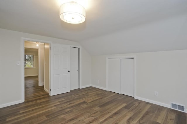 additional living space featuring lofted ceiling, dark wood finished floors, visible vents, and baseboards