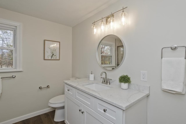 bathroom featuring vanity, wood finished floors, toilet, and baseboards