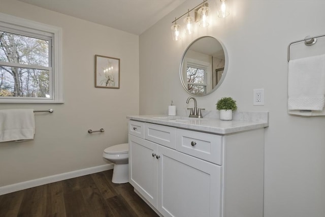 bathroom with vanity, wood finished floors, toilet, and baseboards