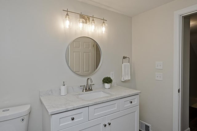 half bath featuring visible vents, vanity, and toilet