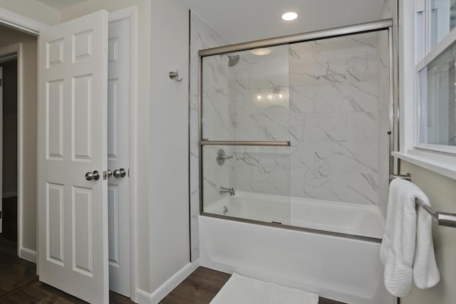 bathroom with combined bath / shower with glass door, baseboards, and wood finished floors