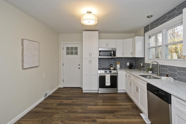 kitchen featuring a sink, visible vents, white cabinets, appliances with stainless steel finishes, and backsplash